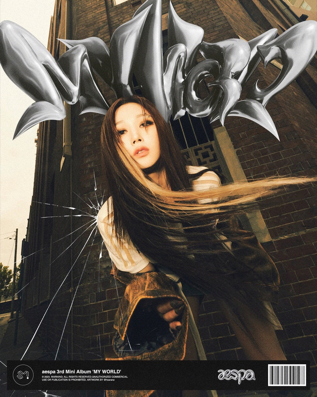 aespa My World poster with member posing in front of brick building and abstract metallic text above.
