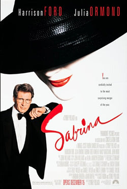 Photographie d’une affiche du film Sabrina montrant Harrison Ford en smoking à côté d’un portrait stylisé féminin avec un grand chapeau noir et des lèvres rouges. L’image reflète l’élégance et le style romantique de cette comédie hollywoodienne réalisée par Sydney Pollack.