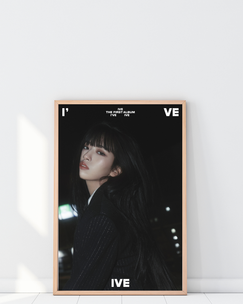 Poster IVE I’ve album encadré dans un intérieur moderne avec décoration murale chic et minimaliste, ambiance élégante avec tons sombres et lumière douce, style K-pop contemporain, Poster Hub Studio.

