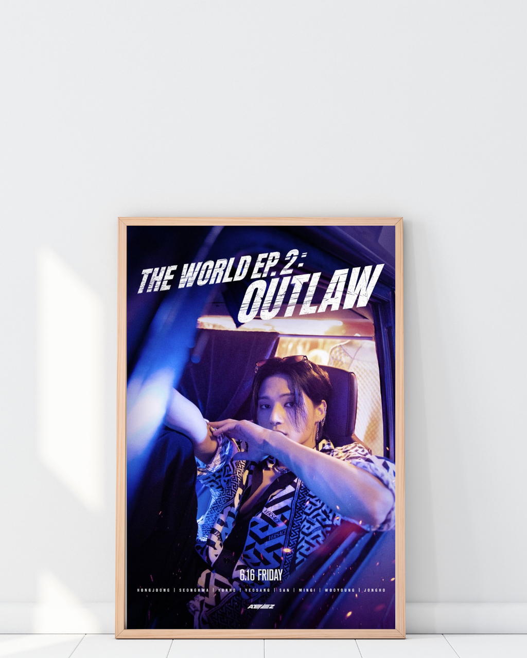 Poster ATEEZ Outlaw encadré dans un intérieur moderne avec éclairage ambiance néon, décoration murale K-pop stylée et contemporaine, tons bleus et violets, esthétique urbaine, Poster Hub Studio.
