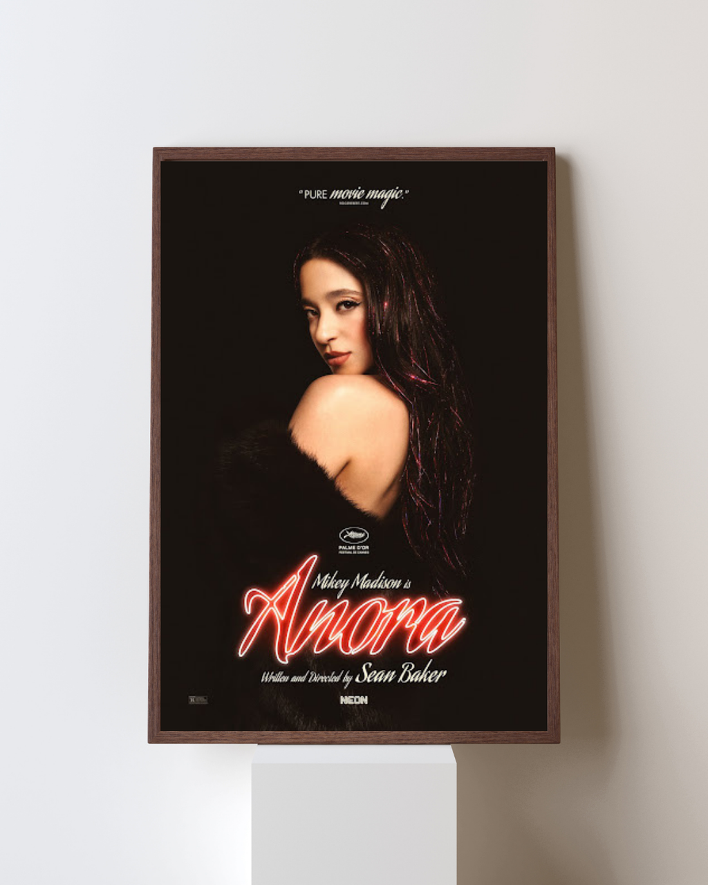 Affiche encadrée de Anora avec portrait féminin et typographie néon rouge, installée dans un intérieur moderne, ambiance chic et cinématographique.
